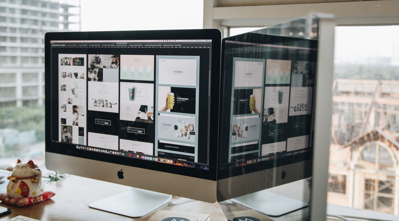 services-02 Dual monitors on a desk, highlighting web design in a contemporary office environment.